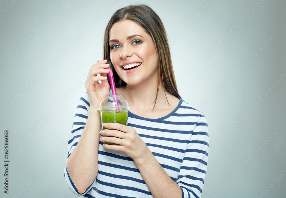 Smiling woman wearing striped holding green detox drink. Smiling woman wearing striped holding green detox drink.