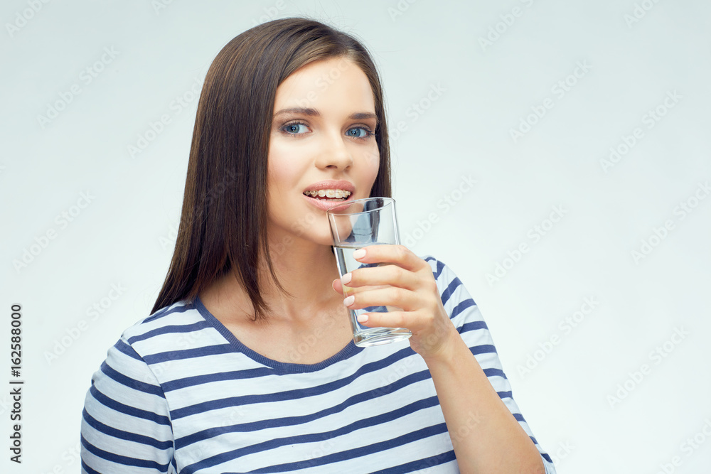 Smiling girl with dental braces drinking water Smiling girl with dental braces drinking water