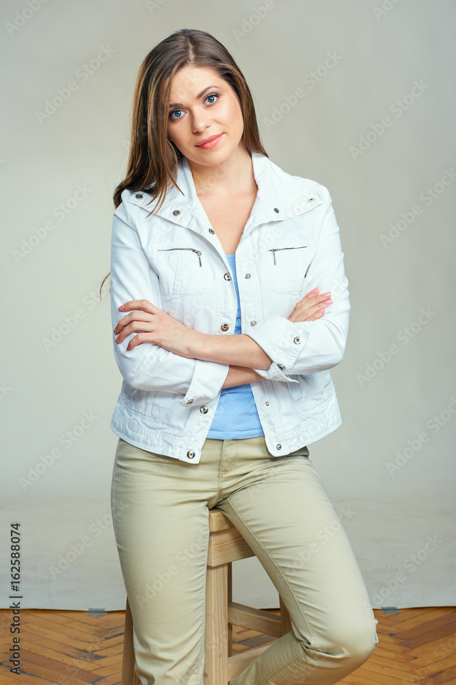 Young smiling woman wearing white jacket sitting on bar chair. Young smiling woman wearing white jacket sitting on bar chair.