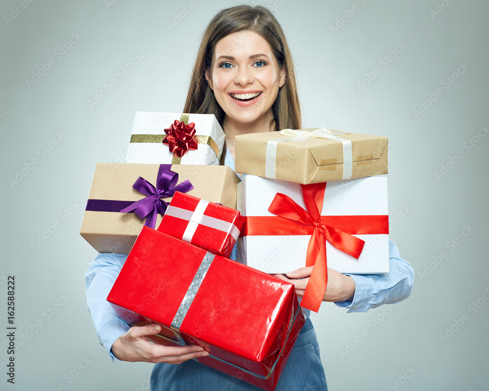 Smiling young woman holding pile of gifts. Smiling young woman holding pile of gifts.