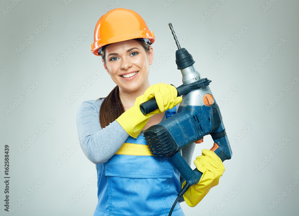 Woman builder holding drill tool. Woman builder holding drill tool.