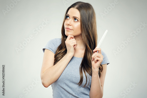 Concept pregnancy photo of young woman holding test.