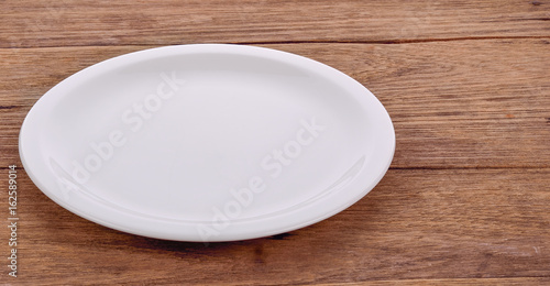 Blank white dish on a wood background