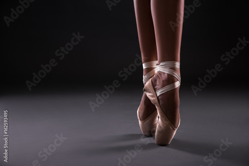 close up of of ballet dancer's feet over gray