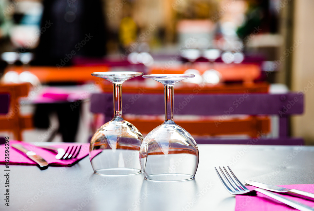 Two wine glasses and cutlery on table in restaurant