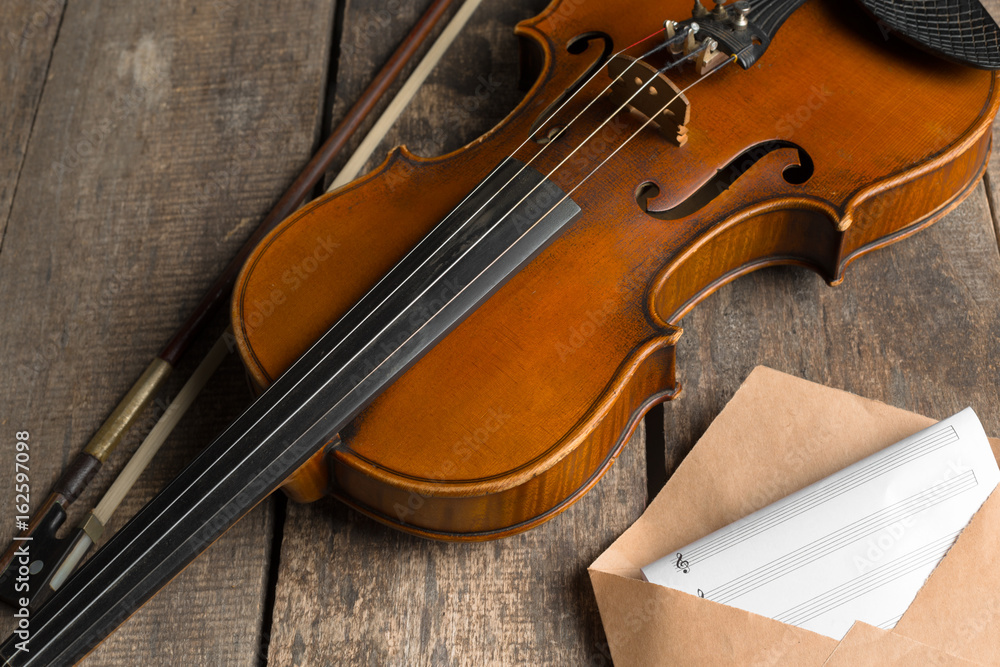 Fototapeta premium Sheet music and violin on wooden table