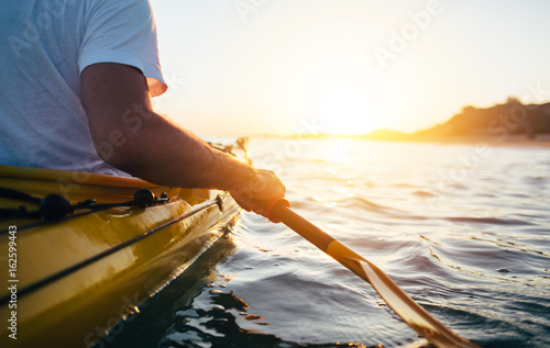 Close up of man holding kayak paddle