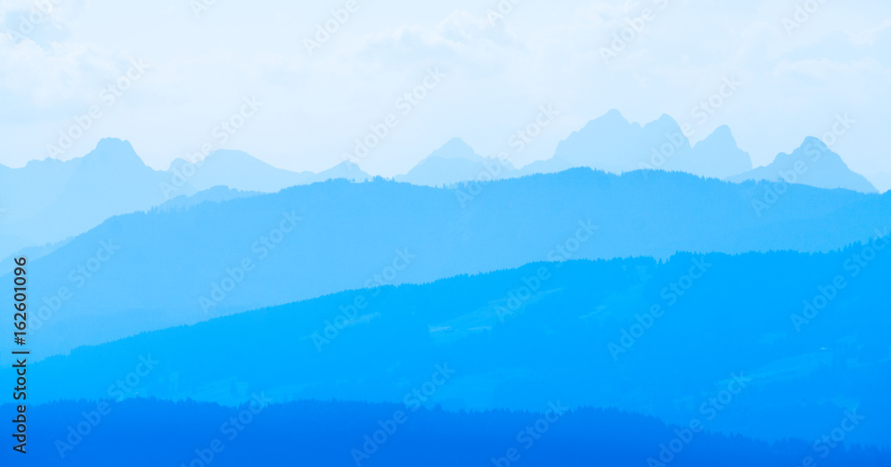 Spectacular view of mountain ranges silhouettes in blue twilight hour
