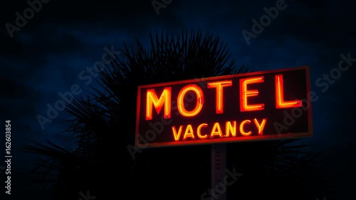 Motel Sign By Tropical Plant At Night