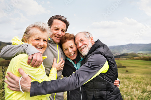Group of senior runners outdoors, resting and hugging. © Halfpoint