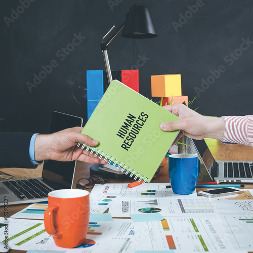 Man giving book which written Human Resources photo