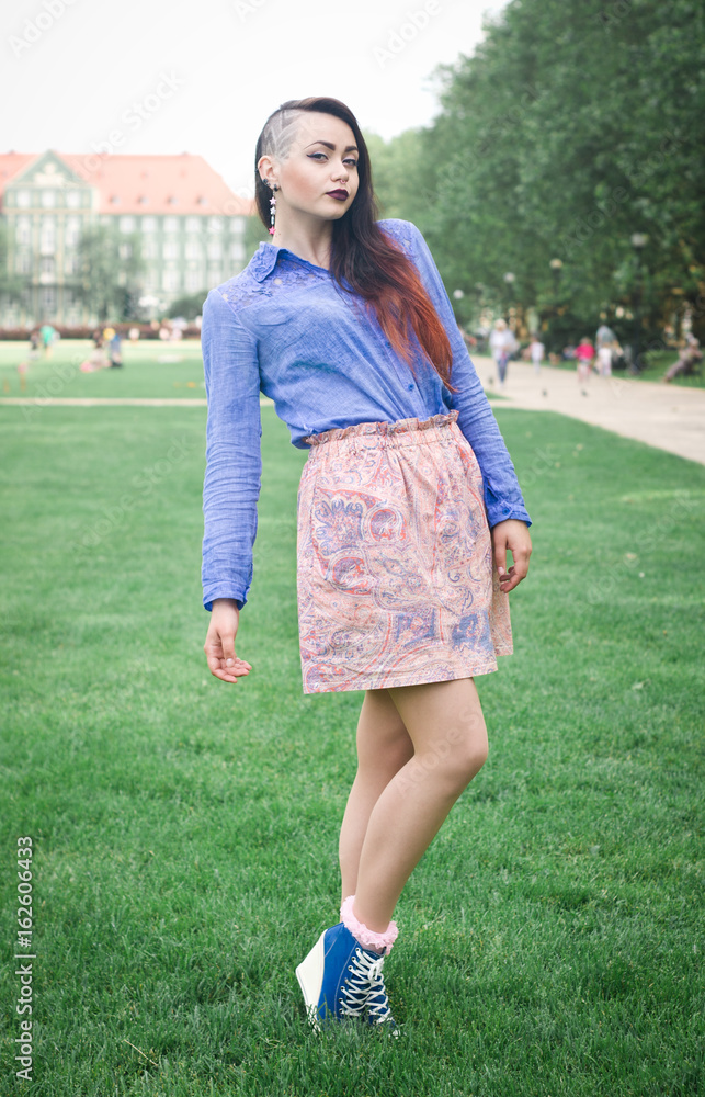 Portrait of a beautiful young brunette girl in a green park
