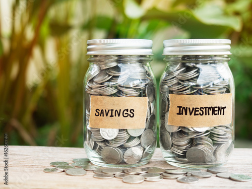 Full of coins in glass jar with savings and investment tap for save money concept.