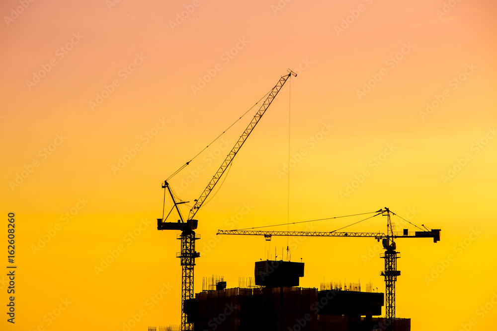 construction cranes silhouette on a beautiful sky day