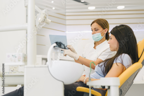 Dentist and patient looking at dental x-ray