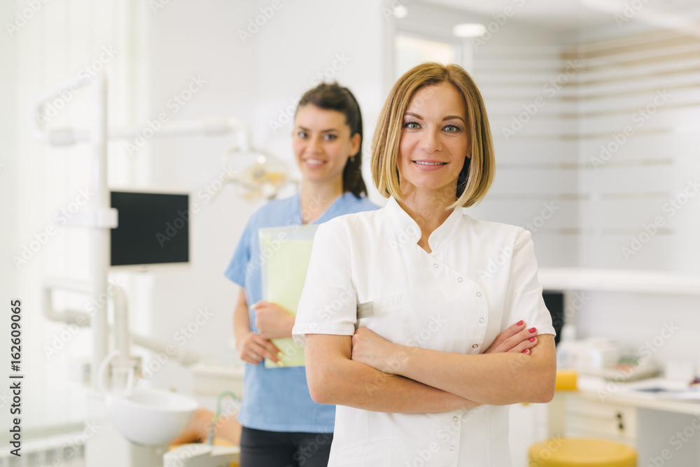 Work is a pleasure for them. woman dentist and her assistant at the dentist office Work is a pleasure for them. woman dentist and her assistant at the dentist office