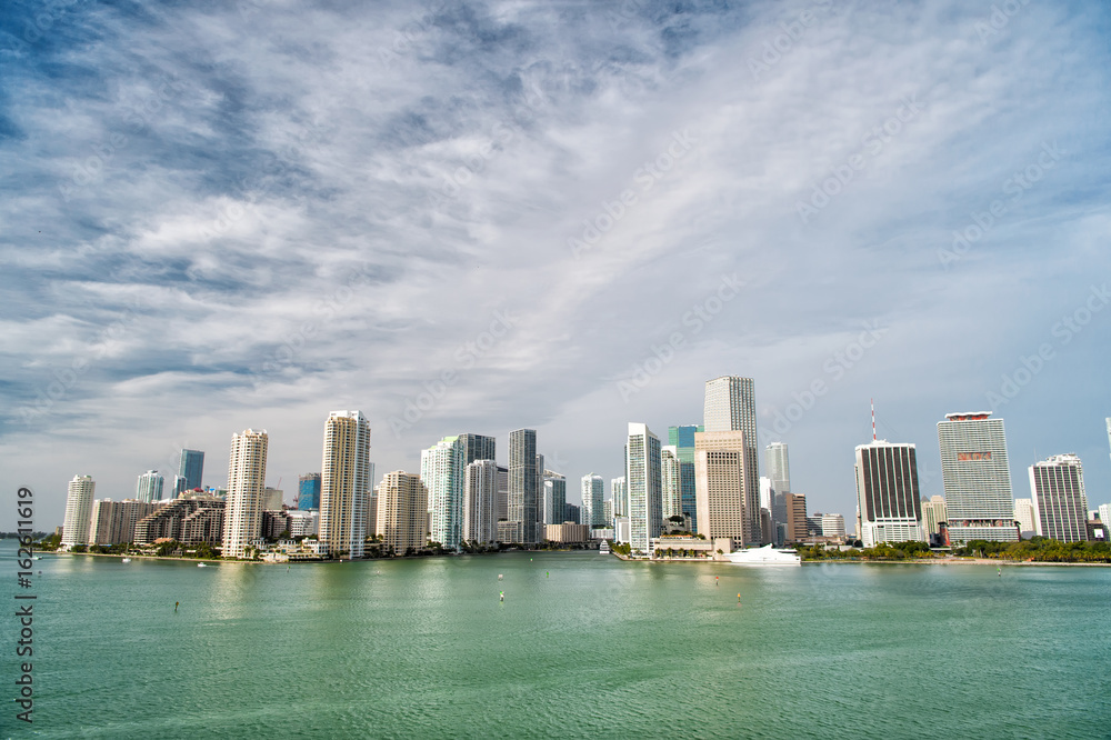 Fototapeta premium Miami skyscrapers with blue cloudy sky, boat sail, Aerial view