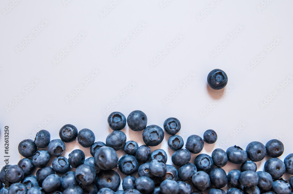 Blueberries isolated on white background. Blueberry border design. Ripe and juicy fresh picked bilberries close up. Copyspace. Top view or flat lay Blueberries isolated on white background. Blueberry border design. Ripe and juicy fresh picked bilberries close up. Copyspace. Top view or flat lay