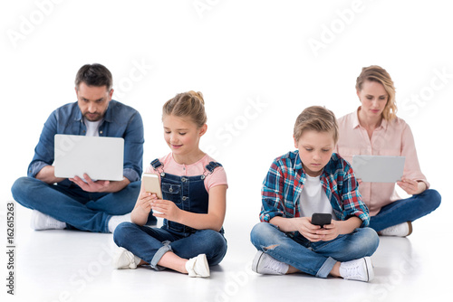 family using smartphones, digital tablet and laptop isolated on white