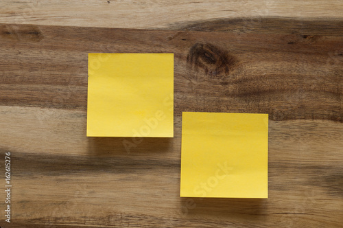 Two post-its on a wooden background. 