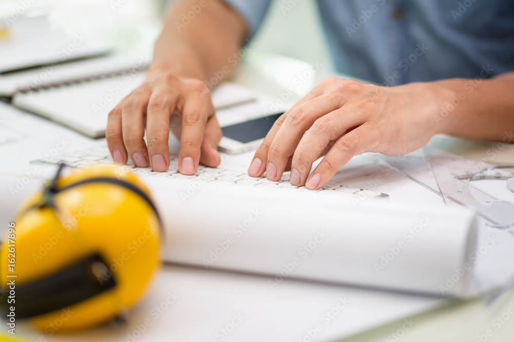 Hands of engineer working with the tool on project drawings background at construction site Hands of engineer working with the tool on project drawings background at construction site