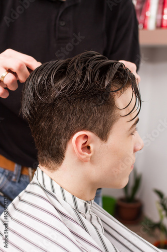 young man getting haircut by barber