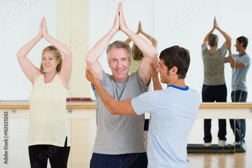 A personal trainer helping a man in a exercising lesson