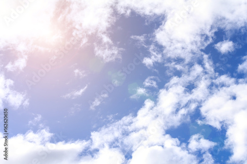 Blue sky background with white clouds, rain clouds and sunshine on sunny summer or spring day.