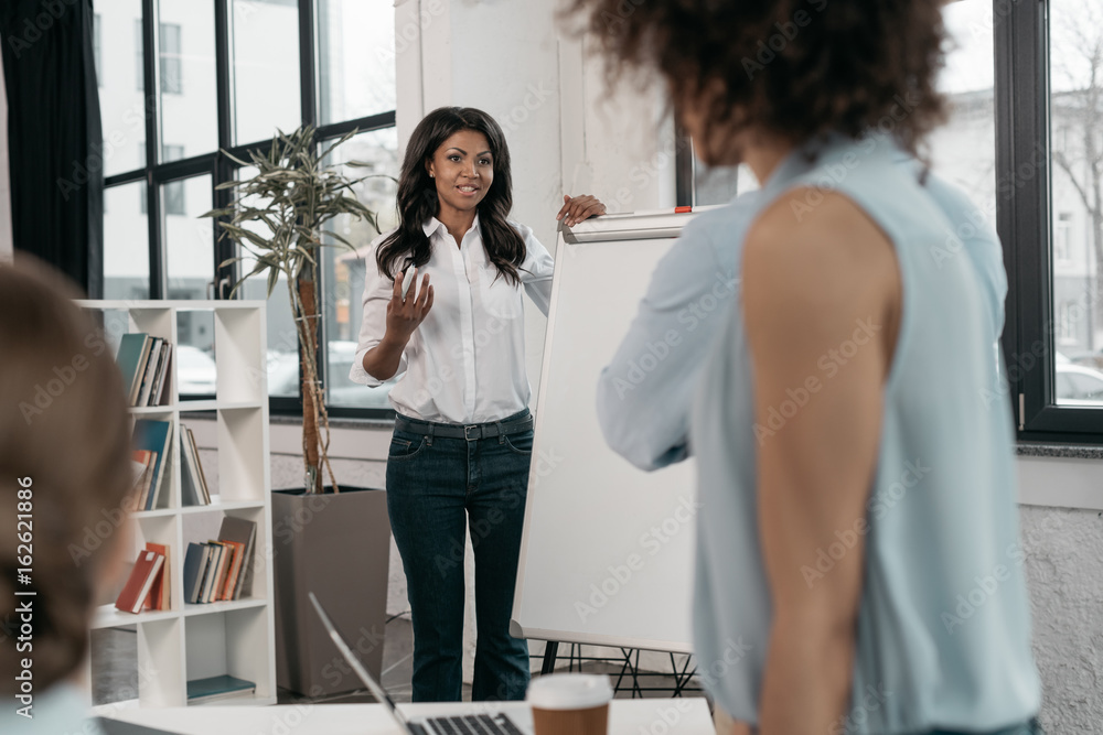 Φωτογραφία young african american woman providing business seminar for her colleagues at of
