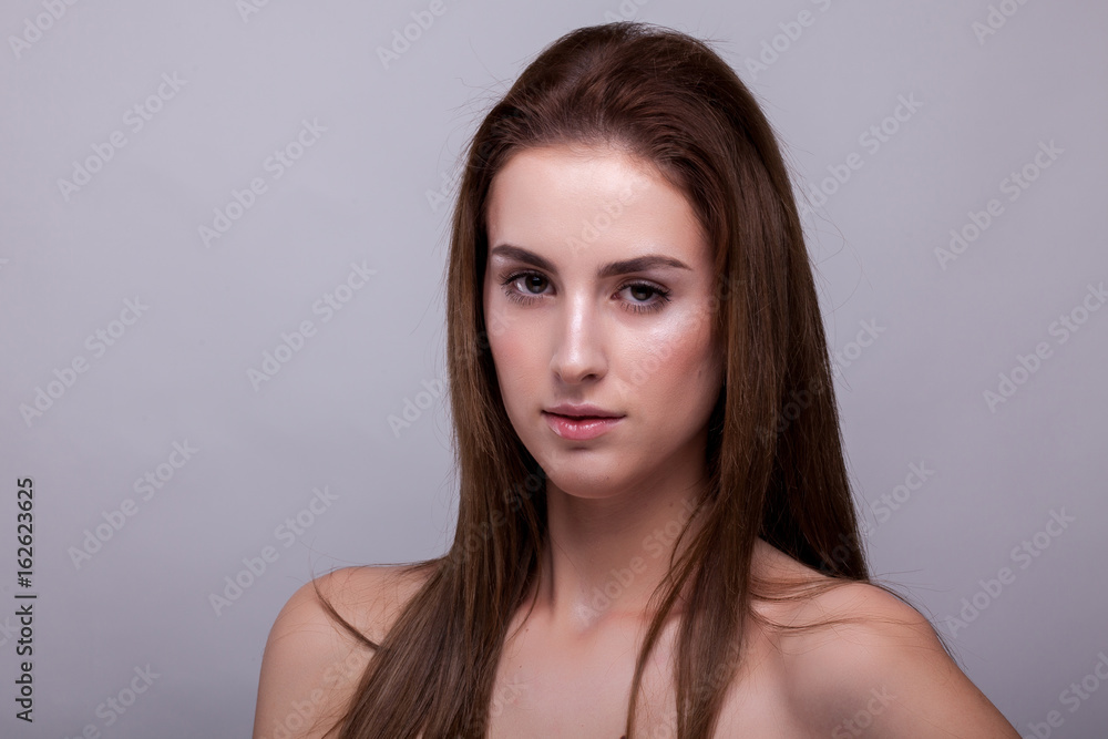 Beauty portrait of woman with no makeup on gray background in studio photo. Beauty and fashion. Beauty portrait of woman with no makeup on gray background in studio photo. Beauty and fashion.