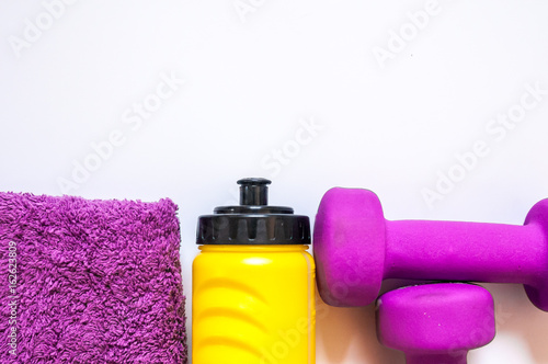Fitness gym equipment. Dumbbells with towel and wate bottler. Workout footwear. Sport trainers on white background. sport, healthy lifestyle and objects concept