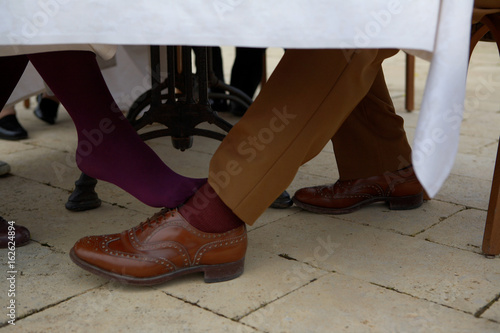 Woman flirting with man under table photo