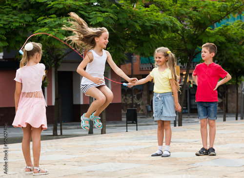 children with jumping rope at playground.