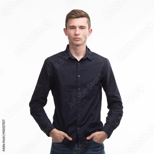 Young serious man portrait of a confident businessman on a gray background. Ideal for banners, registration forms, presentation, landings, presenting concept.