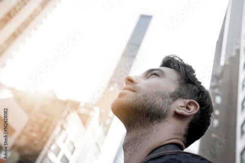 Portrait of man looking at New York city skyscrappers photo