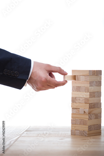 partial view of businessman playing blocks wood game isolated on white