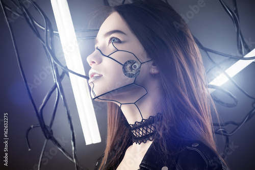 beautiful robot girl in cyberpunk style looking up on background of wires and glowing lamps