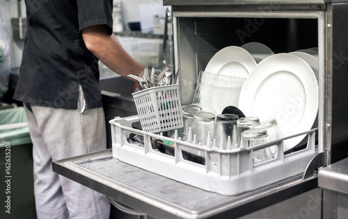 Tableau sur toile Kitchen hand with an open dishwasher