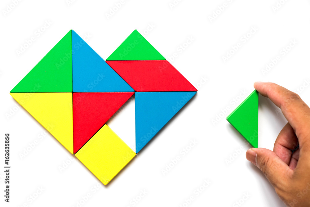 Colorful wooden tangram puzzle in heart shape wait to fulfill with triangle shape on white background Colorful wooden tangram puzzle in heart shape wait to fulfill with triangle shape on white background