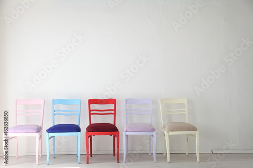 White room with colorful chairs blue yellow red blue purple
