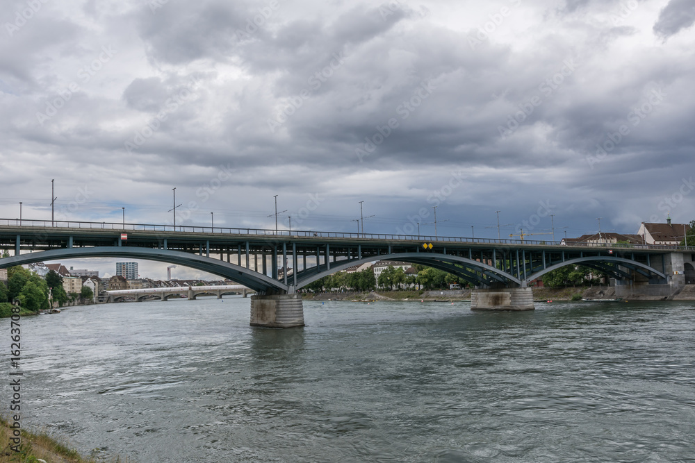 Basel am Rhein mit Brücke und wolkigem Himmel