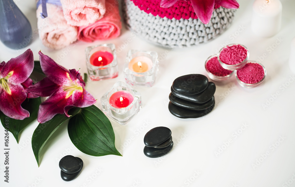 Nature products Spa and wellness setting with flowers, towels, stones and candle Nature products Spa and wellness setting with flowers, towels, stones and candle