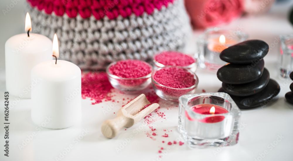 Nature products Spa and wellness setting with flowers, towels, stones and candle Nature products Spa and wellness setting with flowers, towels, stones and candle