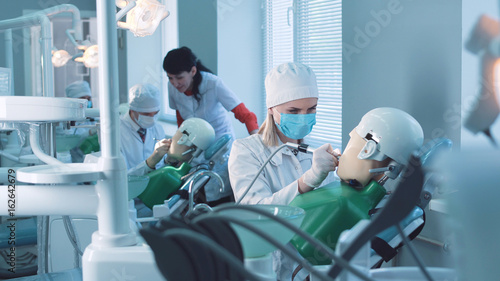 Students practicing dentistry on medical dummies in a teaching facility or university