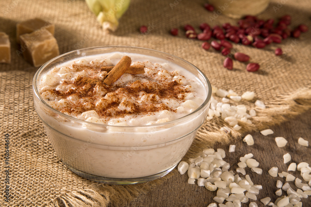 Brazilian dessert canjica of white corn with cinnamon in transparent plate.