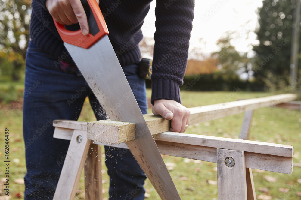 Close Up Of Mature Man Sawing Wood Outdoors Close Up Of Mature Man Sawing Wood Outdoors