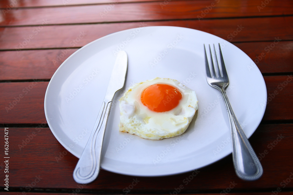 Healthy breakfast with fried egg on wooden table. Healthy breakfast with fried egg on wooden table.