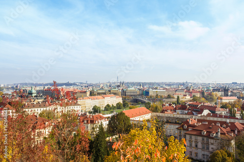 Amazing aerial view from top on Prague, Czech Republic. Yellow trees, red roofs and blue sky.
