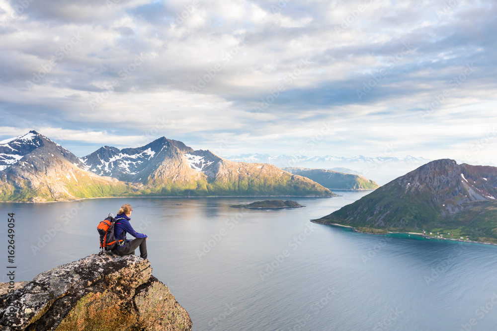 Woman hiker looking at a beautiful Norwegian Fjord landscape Woman hiker looking at a beautiful Norwegian Fjord landscape