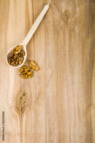 Walnuts in a spoon on a wooden table